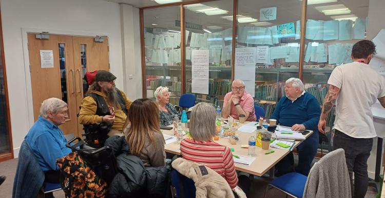 a group of people in discussion while a man takes notes