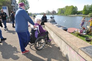 Couple looking at the river, one is in a wheelchair 