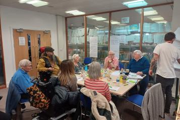 a group of people in discussion while a man takes notes